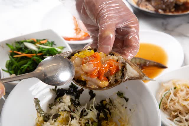 숟가락과 함께 들어 올린 게딱지, 그 아래 김과 밥이 담긴 그릇